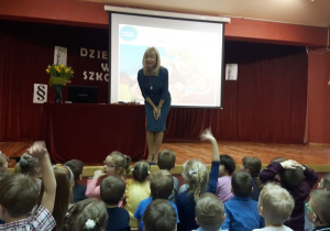 Pani Sędzia stoi na scenie wita się z przedszkolakami na widowni