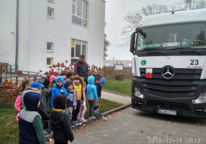 Dzieci stoją obok tira
