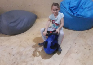 Dziewczynka podczas zabawy, na bujanym koniku