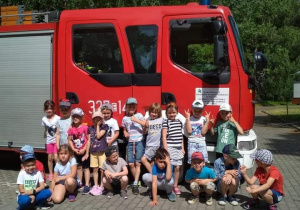 Grupa Sów na tle wozu strażackiego