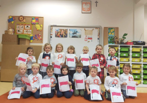 Dzieci z grupy Niedźwiadków z kotylionami oraz z rysunkami flag Polski