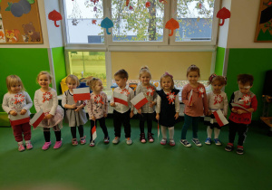 Dzieci z grupy Jagódki z kotylionami oraz z flagami Polski