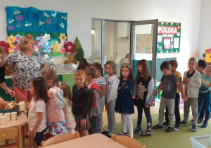Dzieci czekają w kolejce po sok
