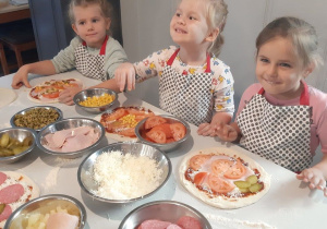 Dzieci ozdabiają pizzę dodatkami
