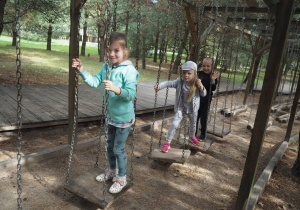 Dzieci podczas pokonywania toru przeszkód, desek wiszących na linach