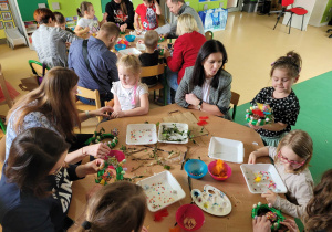 Rodzice z dziećmi robią stroiki świąteczne