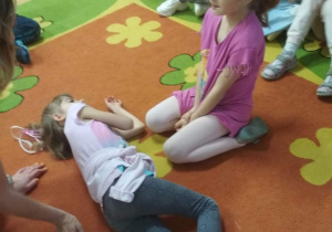 Dziewczynka w bezpiecznej pozycji obok koleżanek