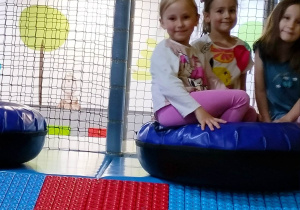 Dziewczynki siedzą na pufie