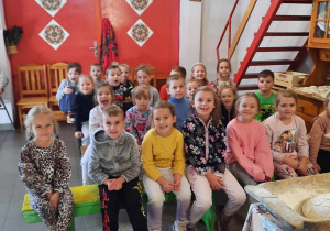Dzieci siedzą na ławce podczas warsztatów