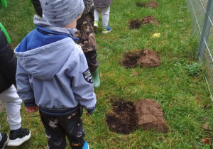 Dzieci oglądają dołki przygotowane do sadzenia