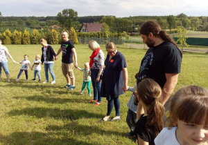 Jabłuszkowe Rodziny podczas zabawy w kole na trawie