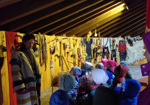 Dzieci w Muzeum Indiańskim obserwują eksponaty powieszone na ścianie