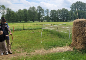 Dziewczynka strzela z łuku przy asekuracji Indianina Jarosława