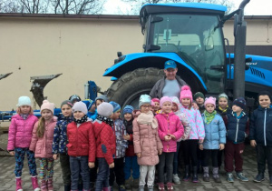 Zdjęcie grupowe na tle traktora wraz z Gospodarzem