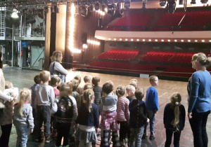 Dzieci wraz z Paniami na scenie Teatru Wielkiego patrzą na widownię