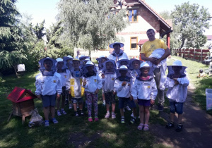 Zdjęcie grupowe Sów z nauczycielką oraz Panem Pszczelarzem w strojach pszczelarskich