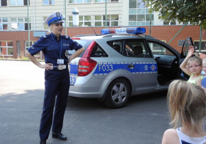 Pani Policjantka stoi obok radiowozu