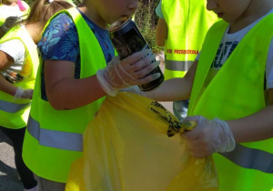 Dzieci segregują śmieci, puszki do żółtego worka