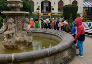 Dzieci przed Pałacem, stoją przy fontannie