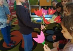 Chłopiec wręcza dziewczynkom kwiaty