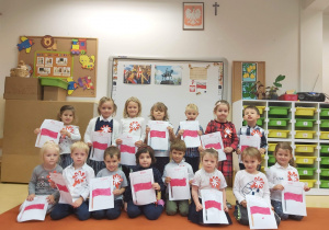 Dzieci z grupy Niedźwiadków z kotylionami oraz z rysunkami flag Polski