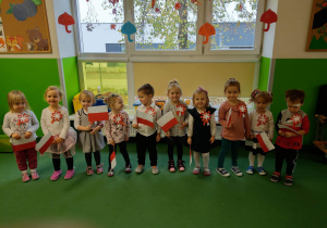 Dzieci z grupy Jagódki z kotylionami oraz z flagami Polski
