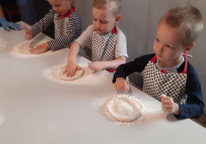 Dzieci wałkują ciasto na pizzę