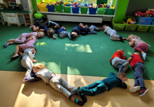 Dzieci odpoczywają w piżamach na dywanie