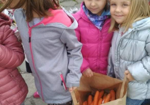 Dziewczynki trzymają torbę z marchewką