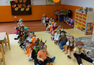 Dzieci podczas zabawy siedzą w dwóch rzędach
