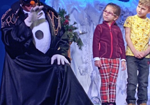Chłopiec i dziewczynka stoją obok aktora na scenie