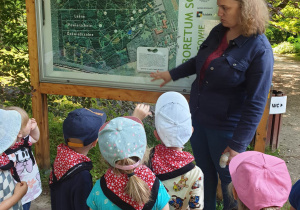 Dzieci z grupy Jabłuszka z Panią Przewodnik pod tablicą informacyjną