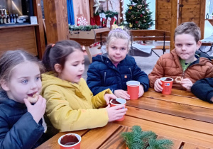 Dzieci podczas picia gorącej czekolady i jedzenia ciasteczek