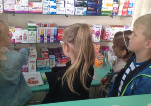 Dzieci na warsztatach w Aptece, oglądają leki na półkach