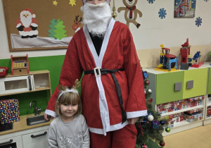 Mikołaj stoi z dziewczynką