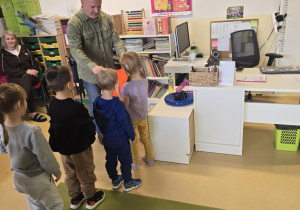 Pan rozdaje kamizelki odblaskowe dzieciom