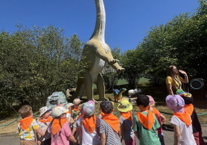 Dzieciaki na ścieżce dydaktycznej w tle dinozaur