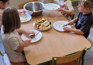 Dzieci podczas krojenia owoców