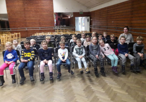 Dzieci z Żabek wraz z Panią siedzą na krzesłach na widowni